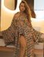Woman wearing a colourful retro print swimsuit and matching robe in a bathroom setting