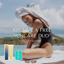 Woman in swimsuit with towel on head by pool, SUZU branding, sun care products displayed